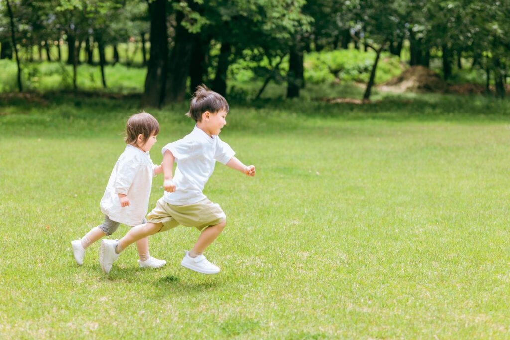 子どもが芝生を走っている写真