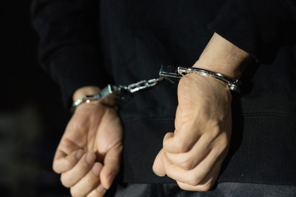 手錠をつながれて逮捕されている人