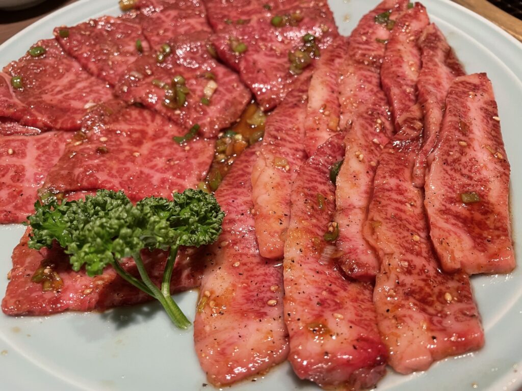 焼肉店で焼肉を食べている女性