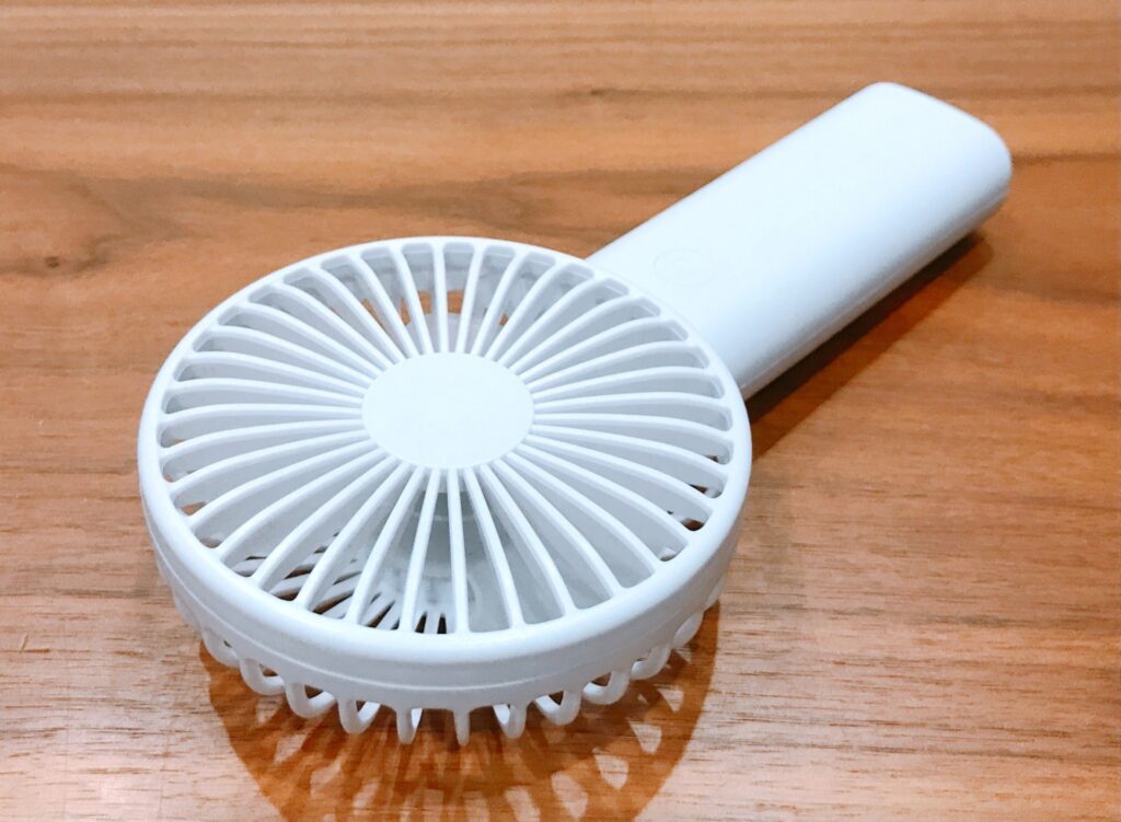 ハンディー型扇風機を使用している人